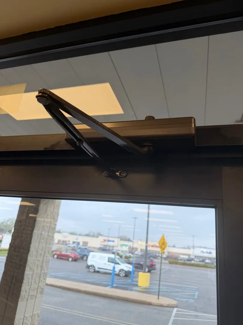 Door closer arm on a storefront entrance