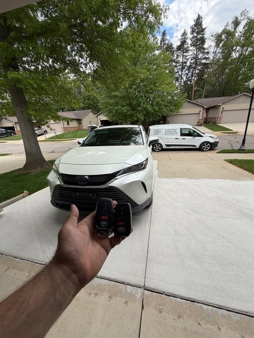 Smart keys for a white Toyota Venza, with the CS Lock and Key van in the background