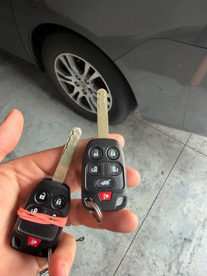 Two Honda remote head keys with sliding door buttons