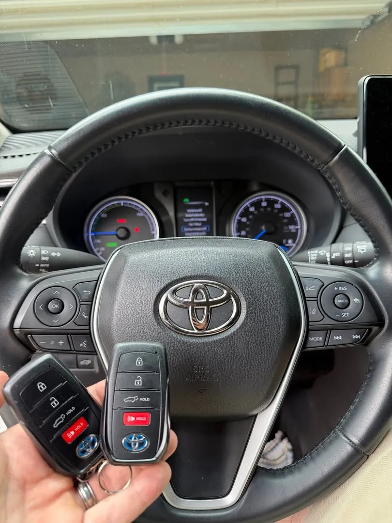 Two Toyota smart keys at the steering wheel of a hybrid