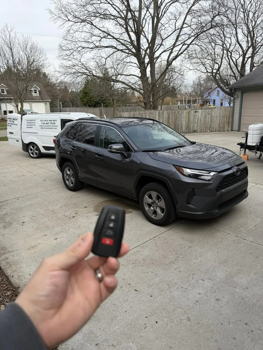 Smart key for a gray Toyota RAV4, with the CS Lock and Key van nearby