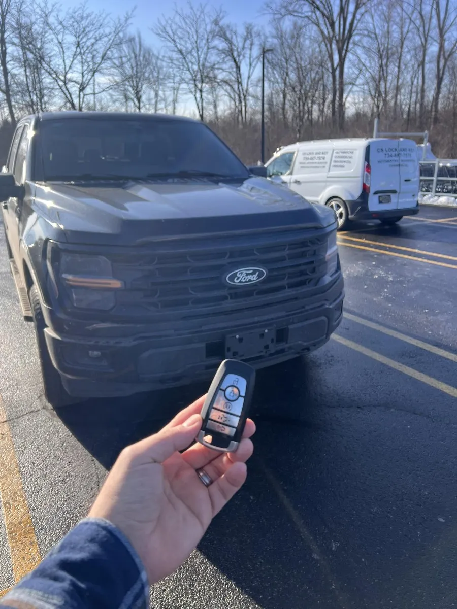 Smart key for a dark Ford F-150, with the CS Lock and Key van behind it