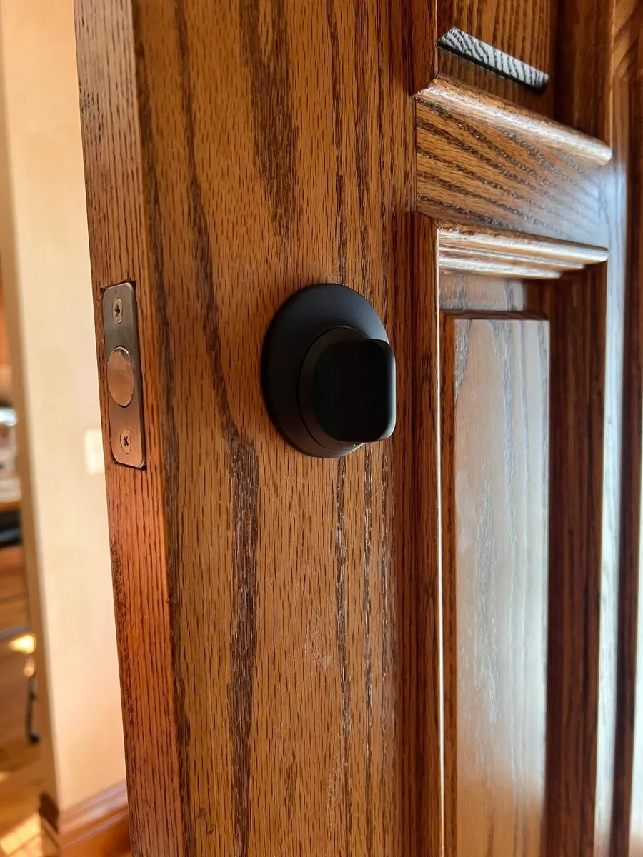 Black deadbolt thumb turn on a wood door