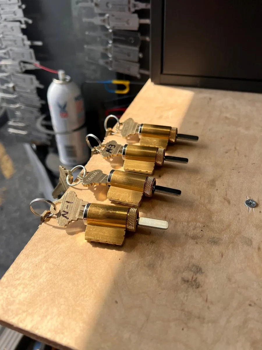 Rekeyed brass lock cylinders with keys on a workbench