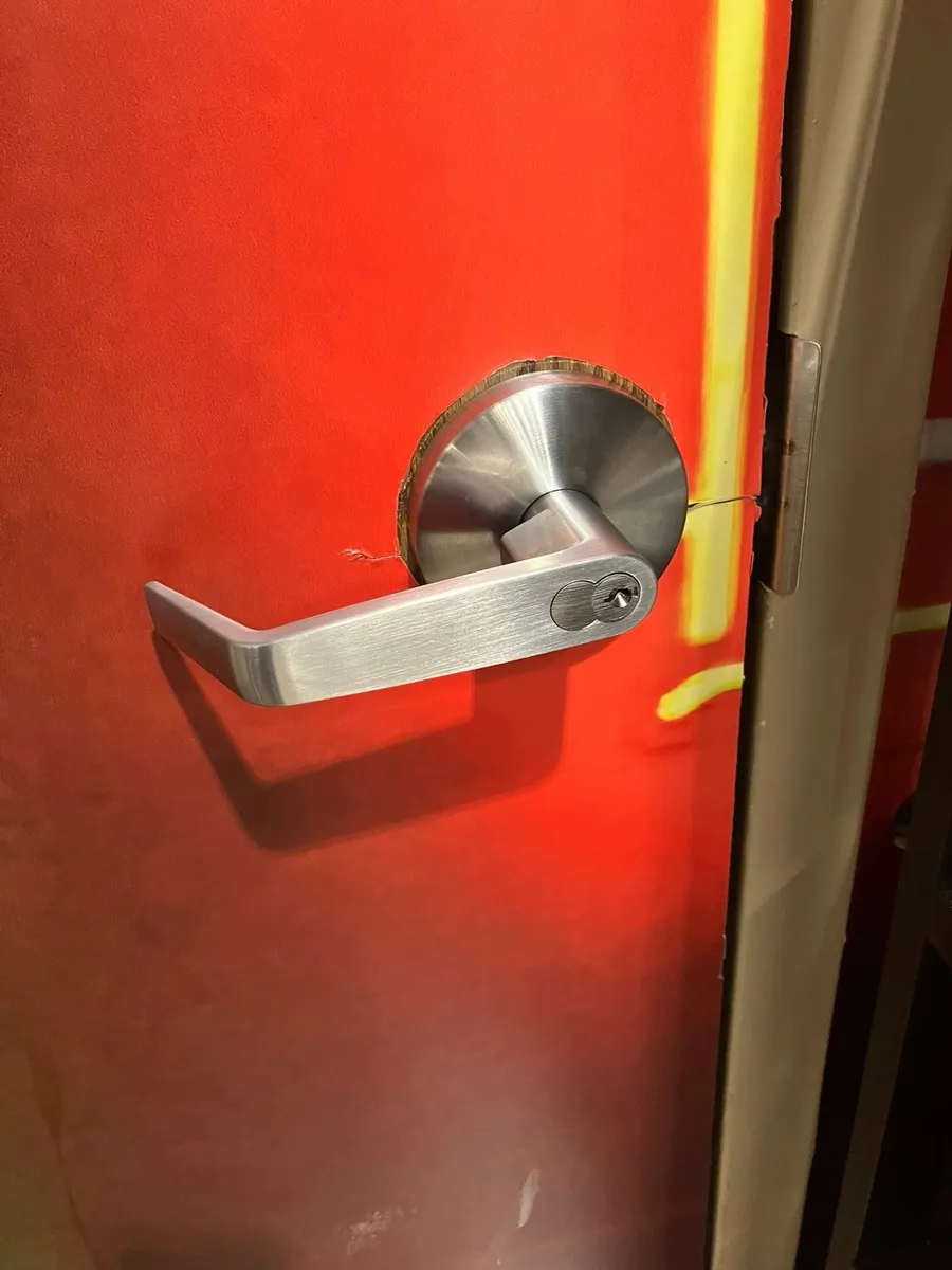 Brushed nickel lever on a red door