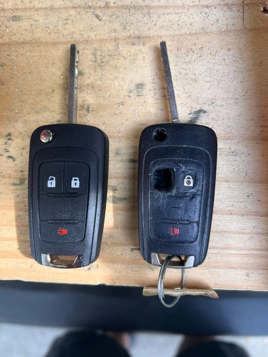 Old and new Chevrolet flip keys on a workbench