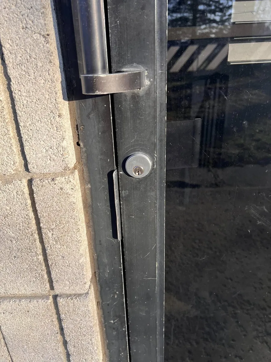 Lock cylinder and handle on a storefront door