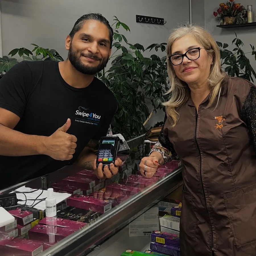 Agustin from Swipe4You holding a card terminal with Irene, owner of Danny's Unisex in Waukegan, IL