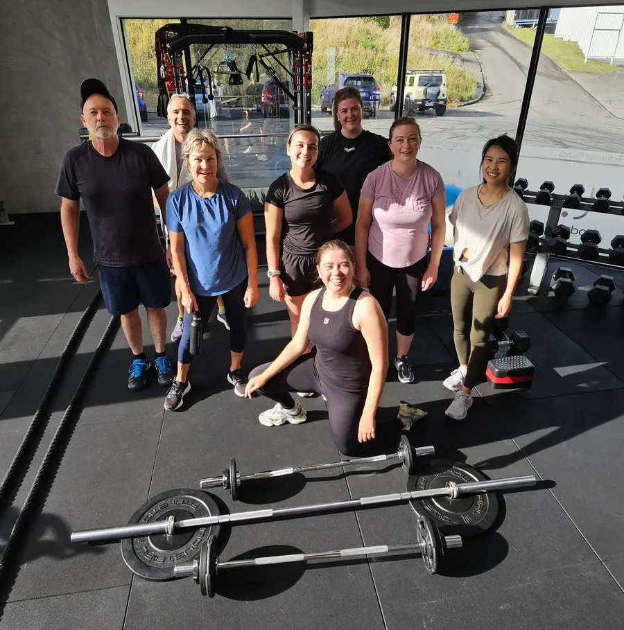 A bodyco. training group together in the Seaview studio, with weights and training equipment