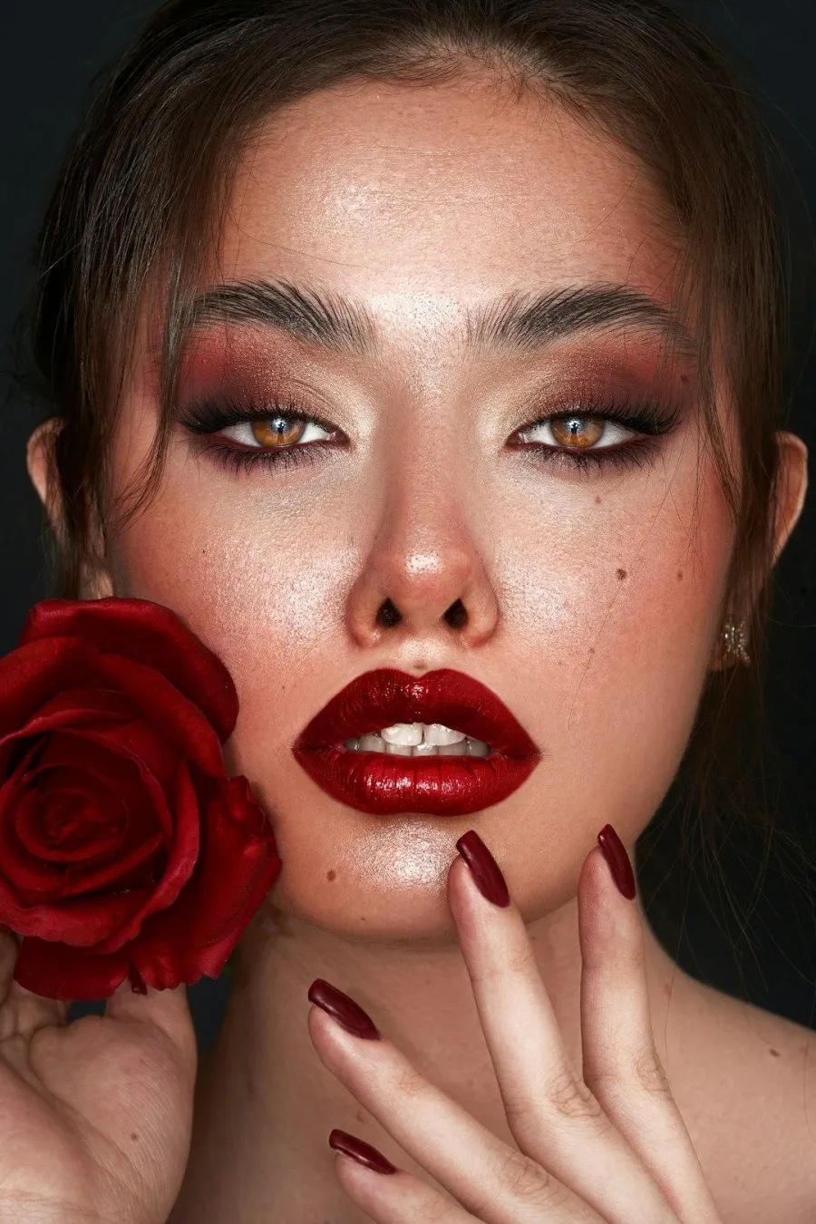 Editorial beauty close-up with a glossy red lip and a red rose