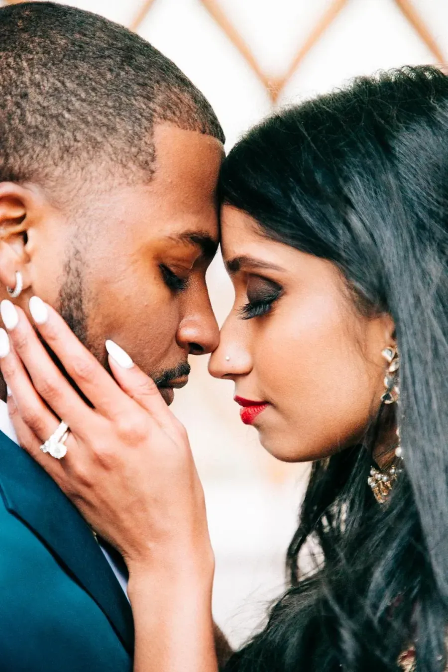 Couple touching foreheads, bride with statement earrings and soft glam