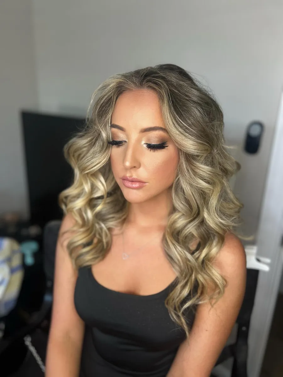 Guest with soft glam makeup and loose waves styled for a gala