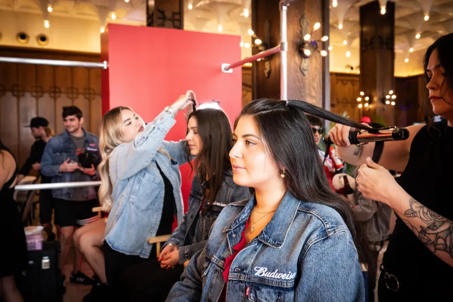 Artists curling and styling guests' hair side by side at a busy brand activation