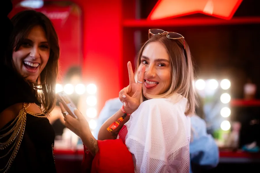 Two guests posing after glam in front of a Hollywood mirror in the lounge