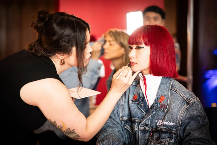 City Lights artist applying lip color to a guest in the Budweiser glam lounge at Lollapalooza