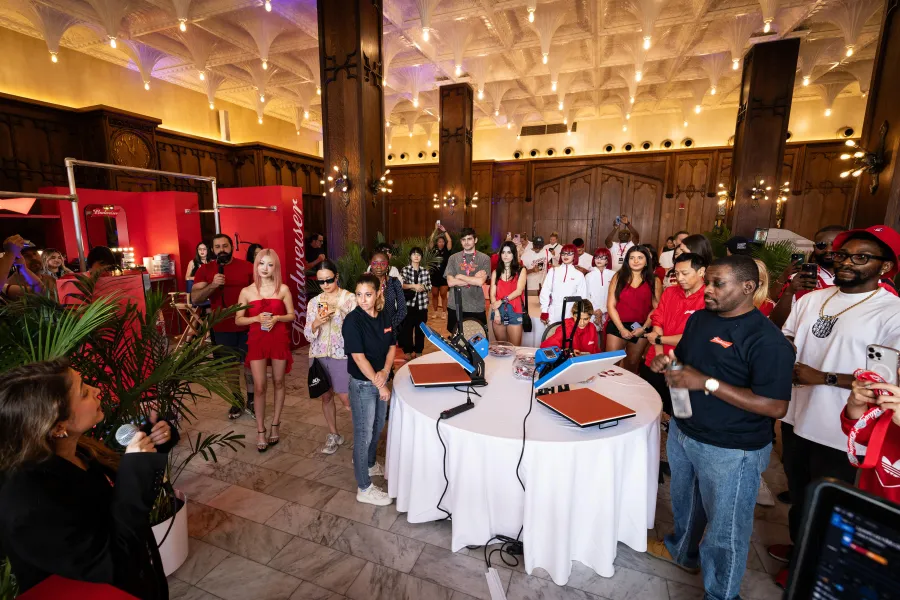 Wide view of the Budweiser VIP lounge floor filled with guests and stations