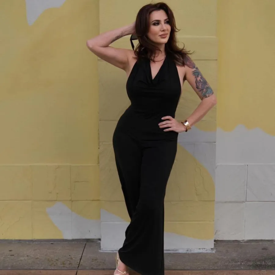 Paula Heckenast, founder of City Lights Beauty Agency, in a black jumpsuit against a painted wall