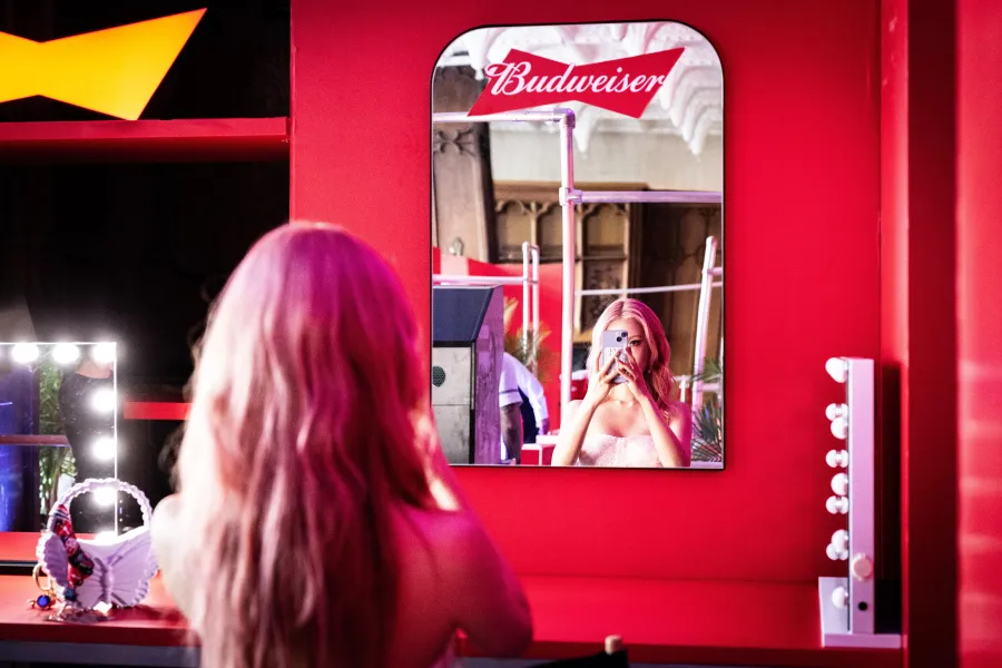 Guest at the vanity mirror in a red Budweiser branded glam booth