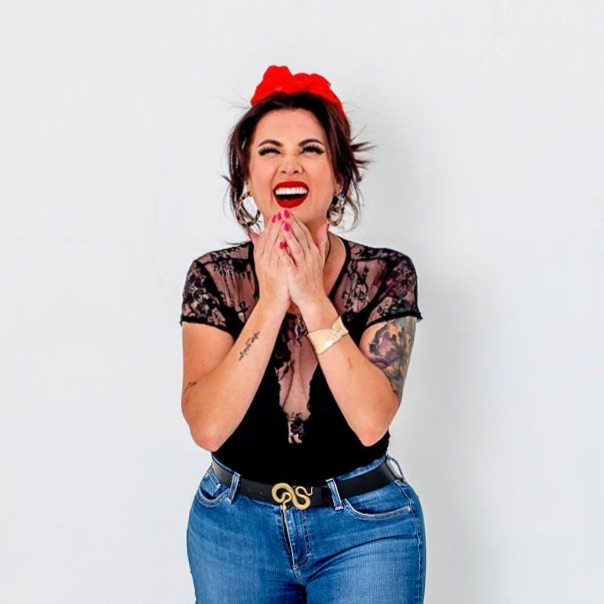 Paula Heckenast laughing, hands clasped, in a red headband