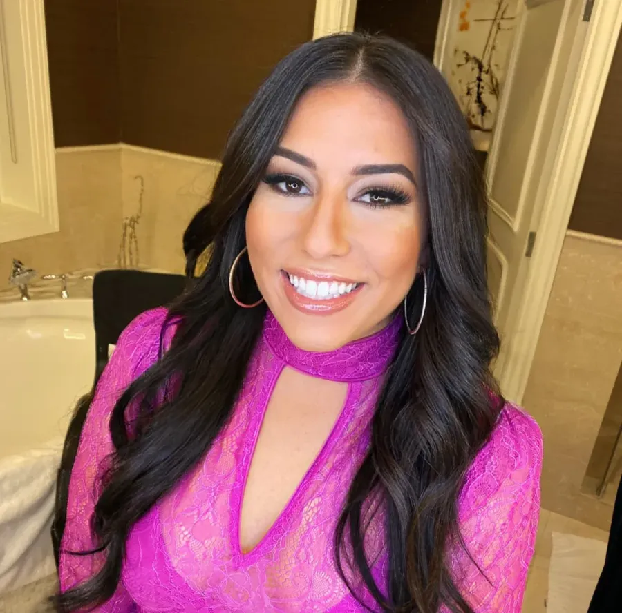 Guest in a pink lace dress with long waves and warm glam makeup for an evening event