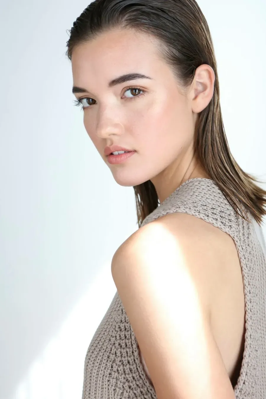 Minimal beauty portrait with dewy skin and slicked hair