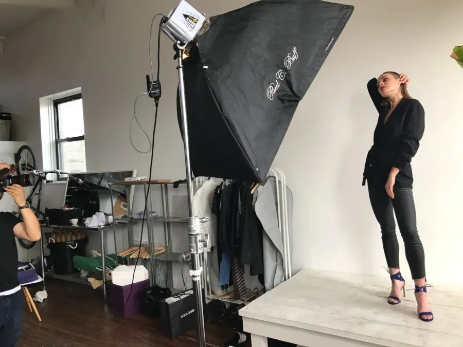 Studio set with a softbox lighting a model against a seamless backdrop