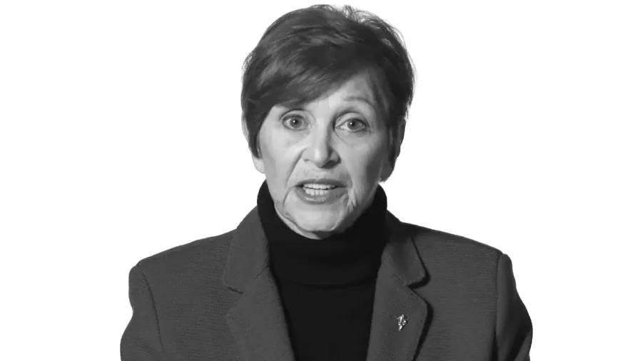 Black and white interview portrait of a woman in a dark blazer against a white backdrop
