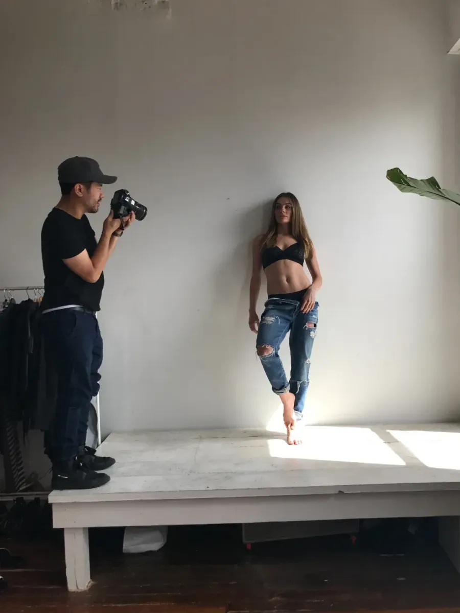 Photographer shooting a model on a studio cyc wall during a Chicago commercial production