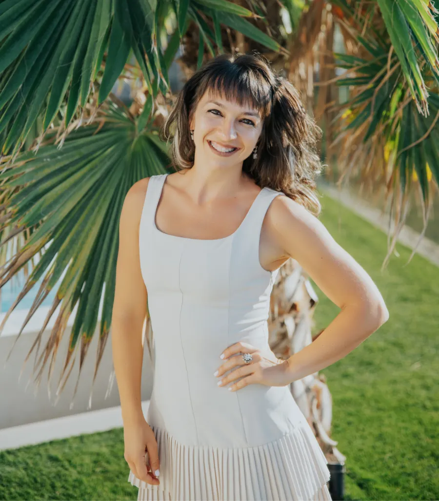 Marchela standing beneath palm trees