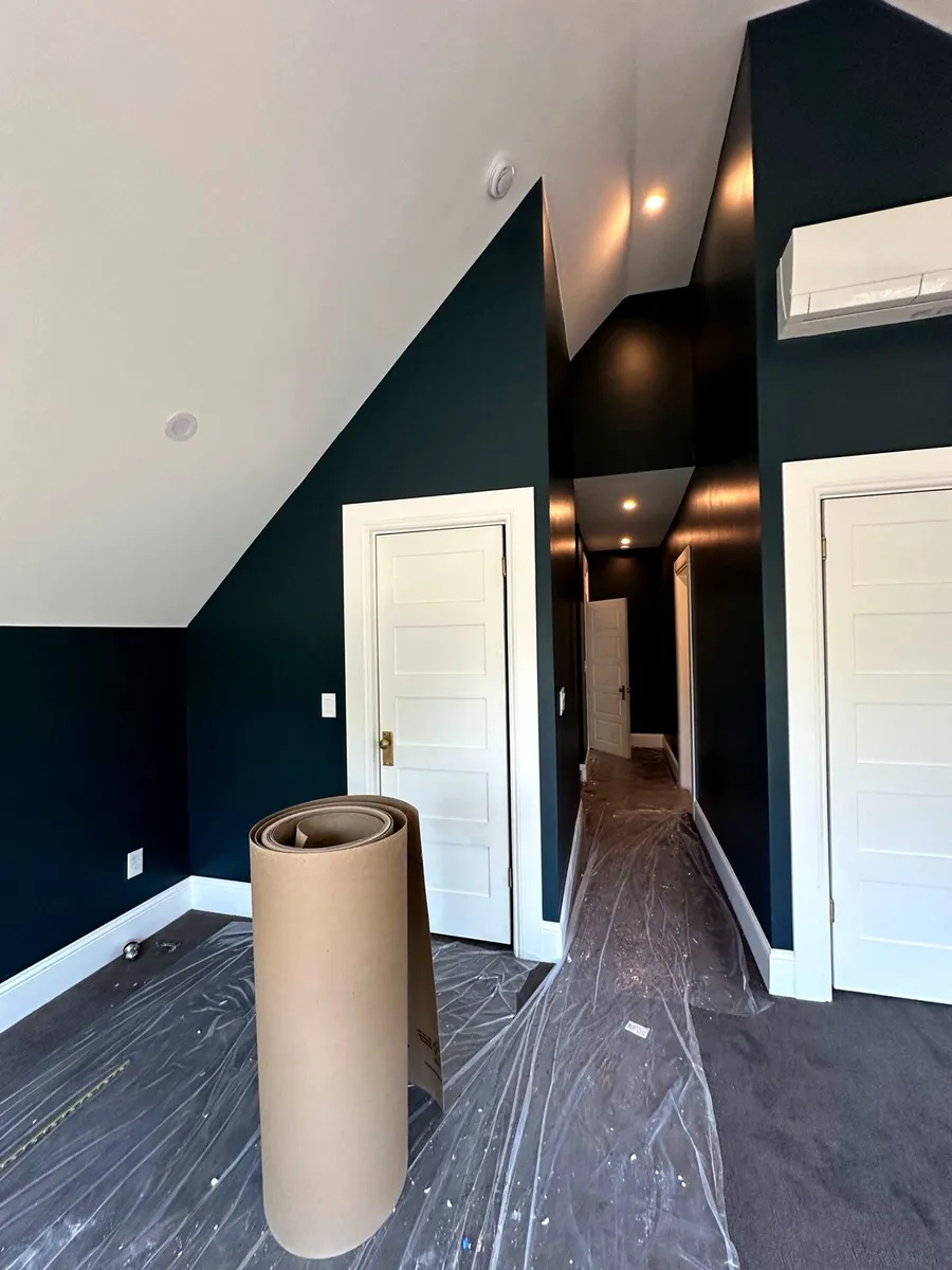 Upstairs room with deep teal accent walls and white trim