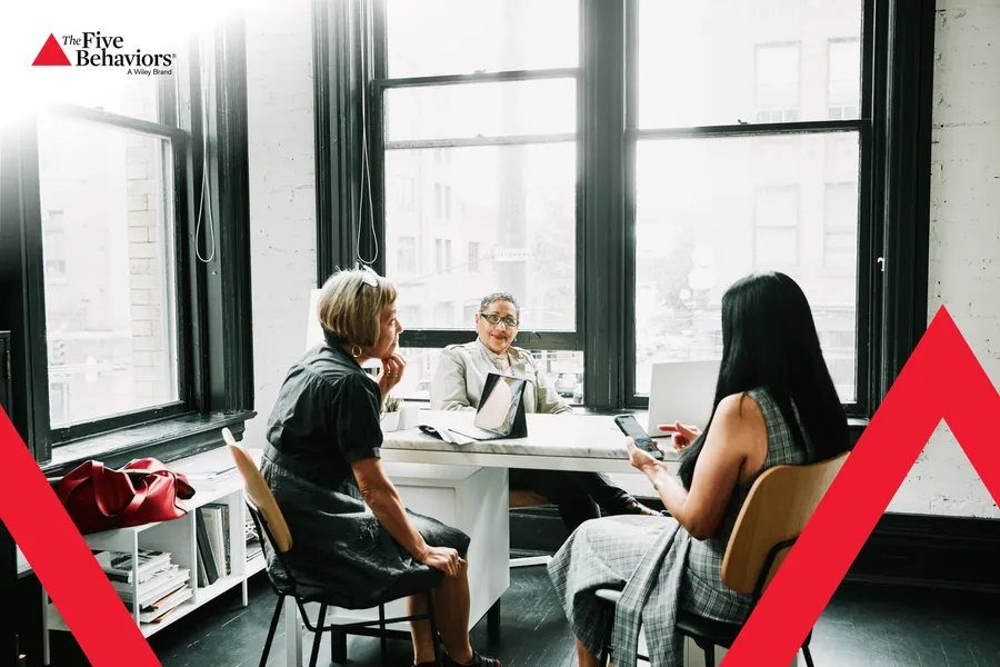 Colleagues in discussion at a desk. Photo: The Five Behaviors®