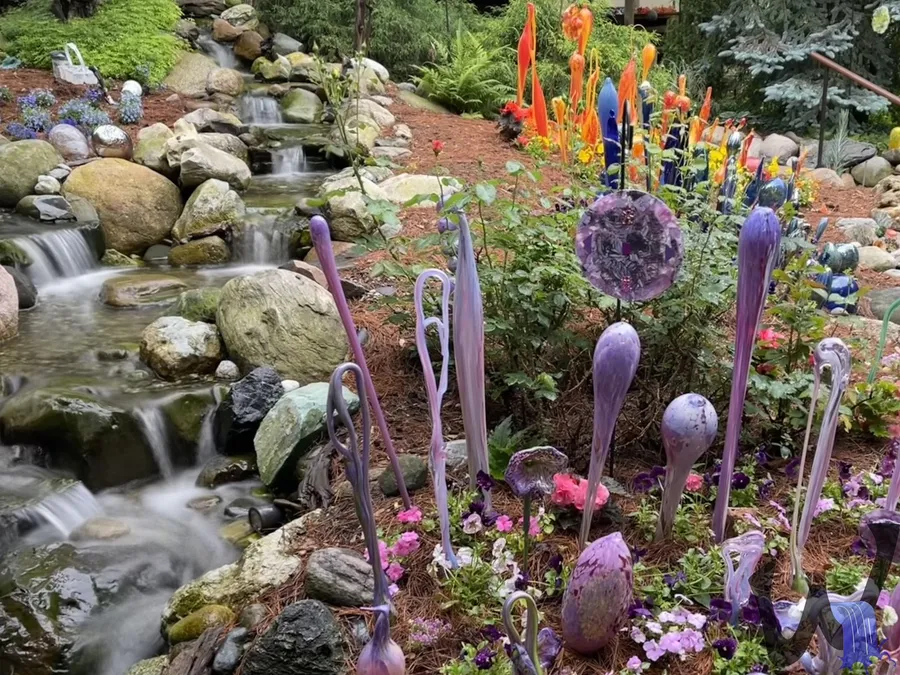 Garden waterfall surrounded by flowering plants