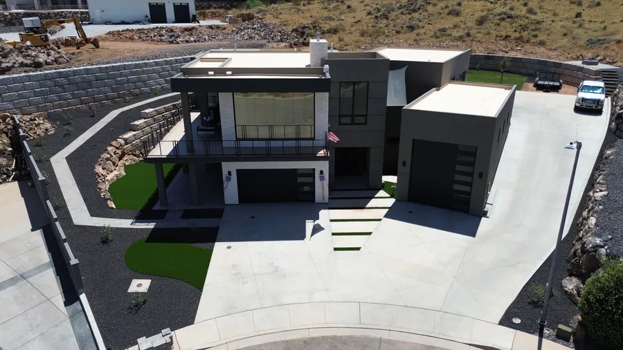 Modern home with finished turf and hardscape, aerial view