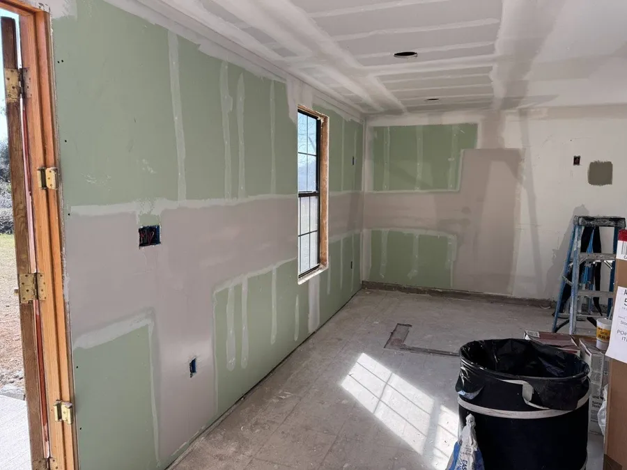 Room with new green board drywall taped and finished