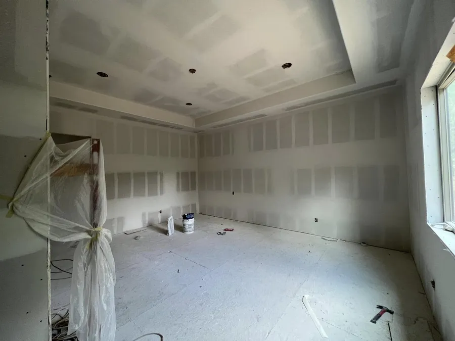 Room with a tray ceiling and freshly finished drywall seams