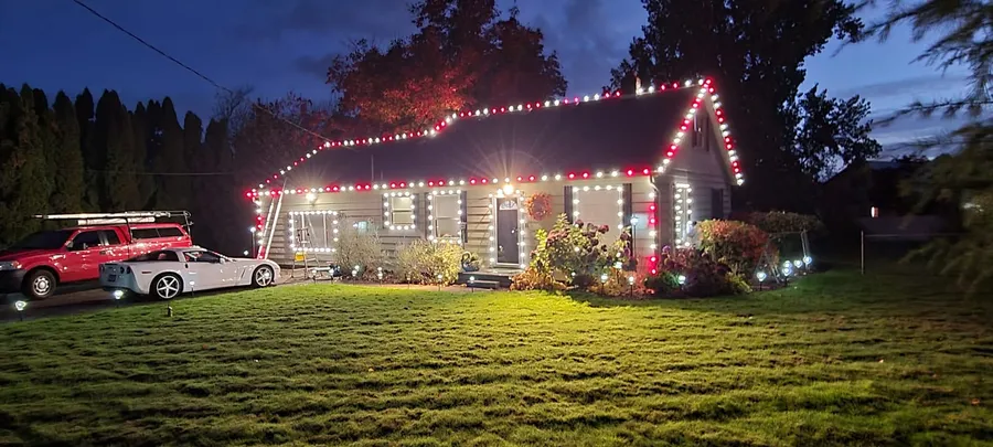 Single-story home with red and white roofline and window lights