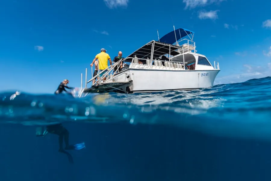 Embarcación de buceo con buzos entrando al agua