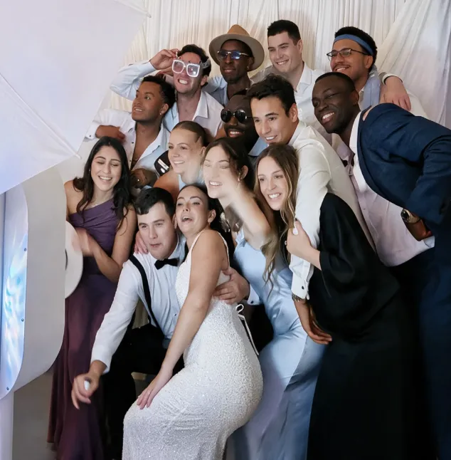 Large group of wedding party guests laughing together at a Photo-N-Go photo booth