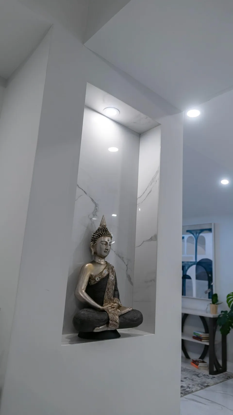 Custom illuminated wall niche with marble-look finish and recessed lighting