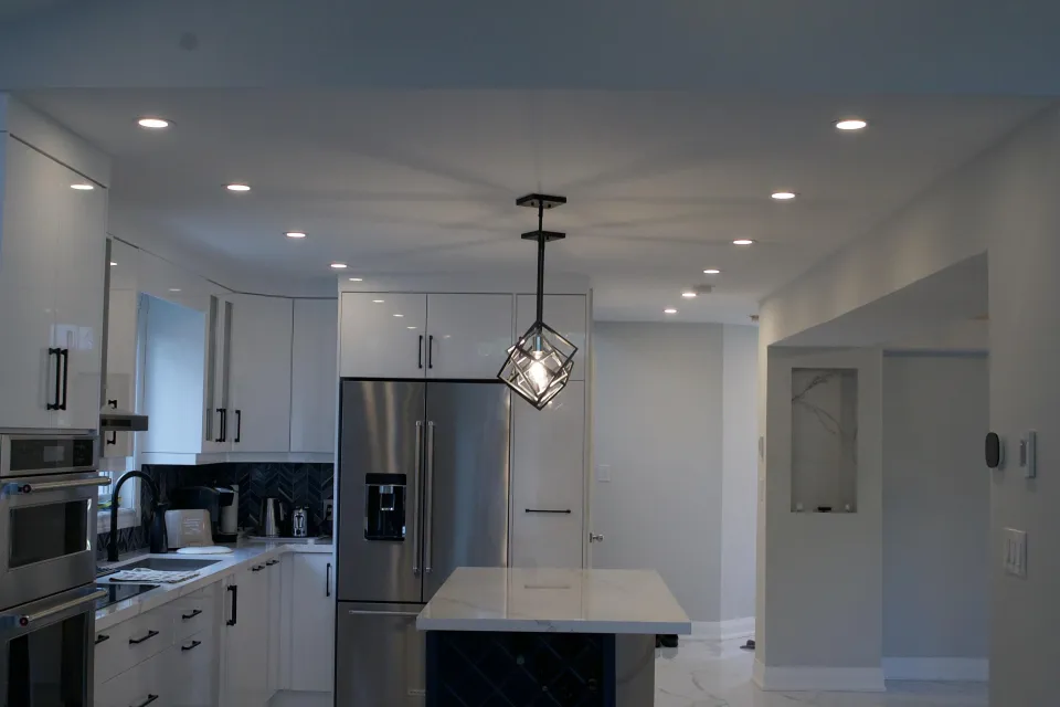 Kitchen with black island, pendant light and recessed lighting