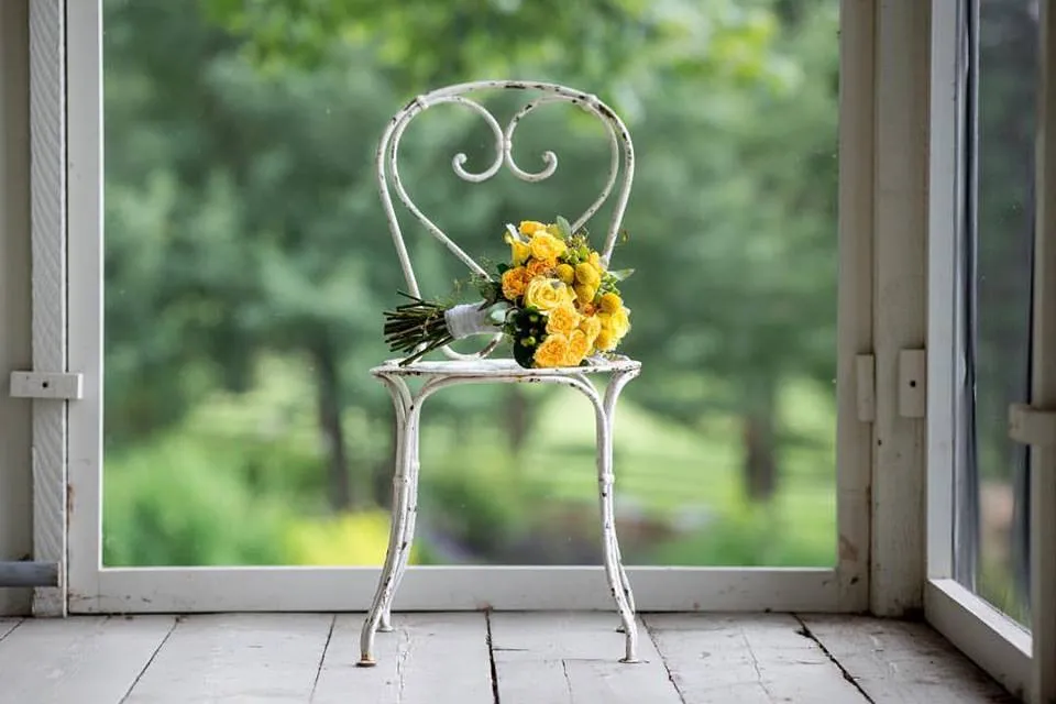 Touche florale jaune sur une chaise de cérémonie en jardin