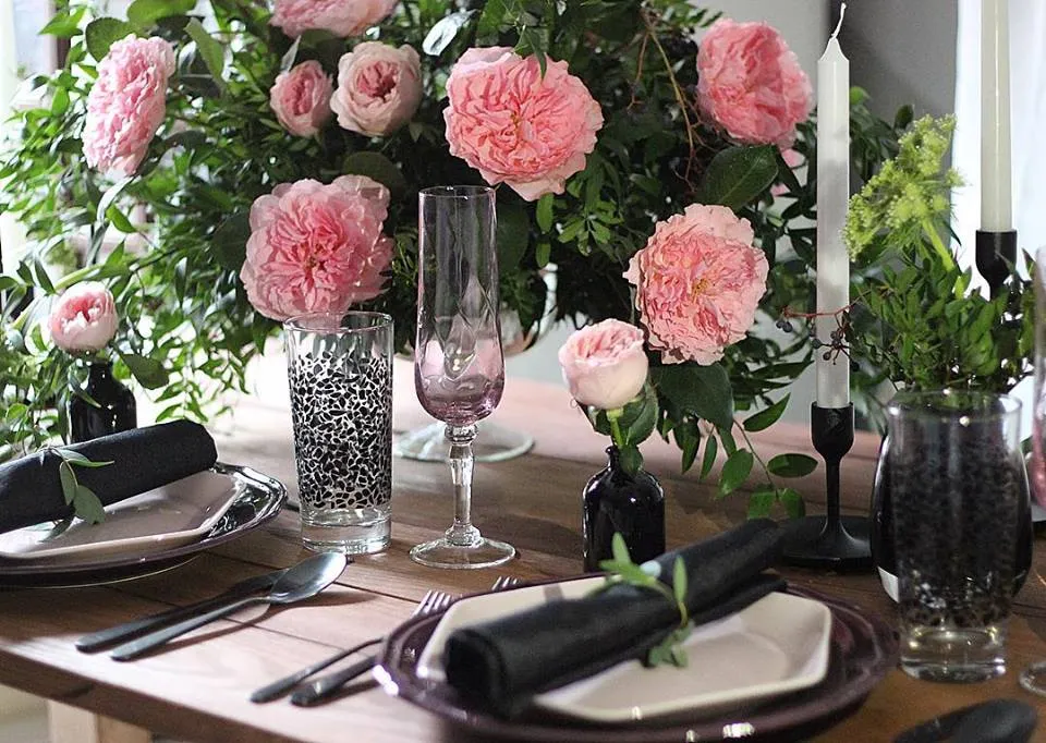 Pink garden roses and glassware on an event table