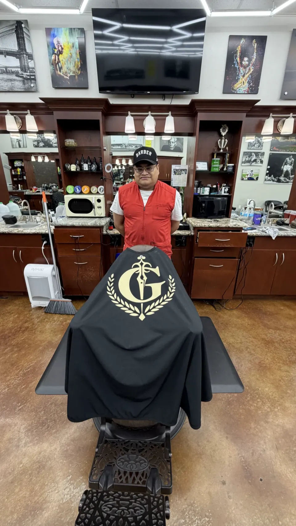 Frankie Fresh and the cape, with the full shop behind him