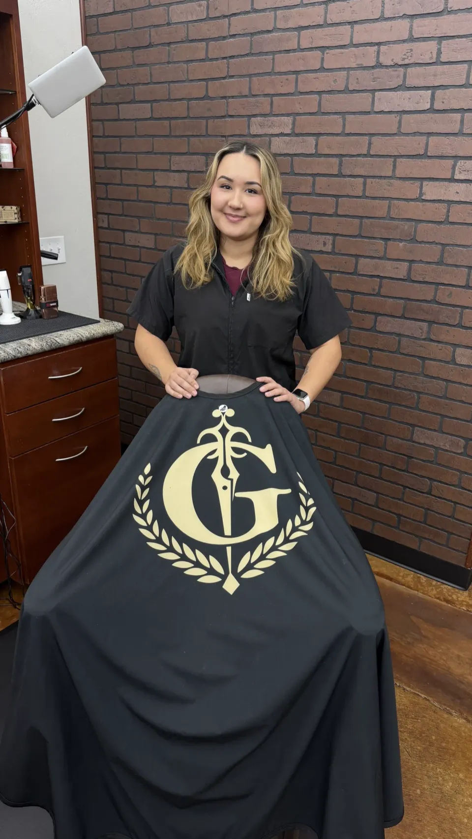 Mariah smiling behind the Gentlemen's Cutz cape