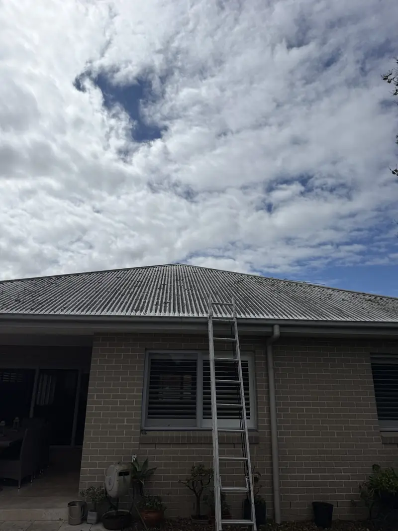 Grey Colorbond roof on a brick house with dark streaks before cleaning