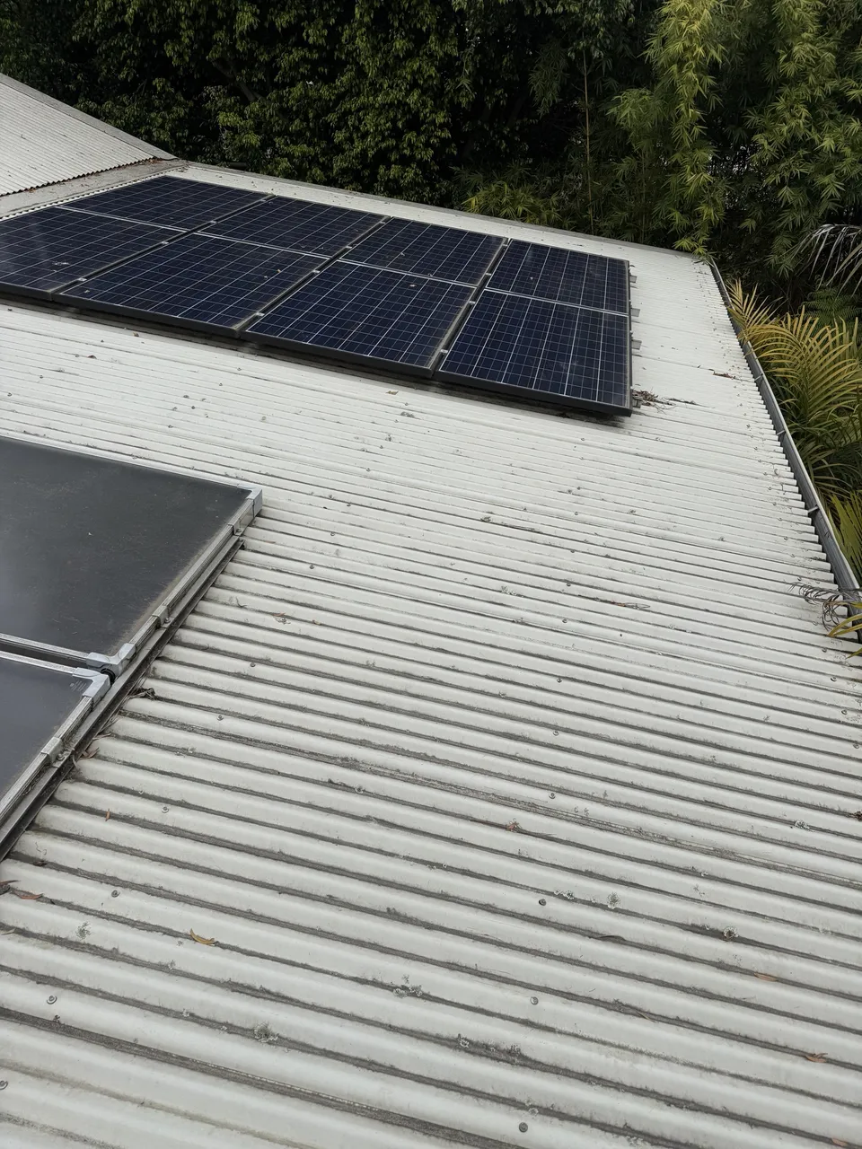 Metal roof and solar panels dusty and dull before cleaning