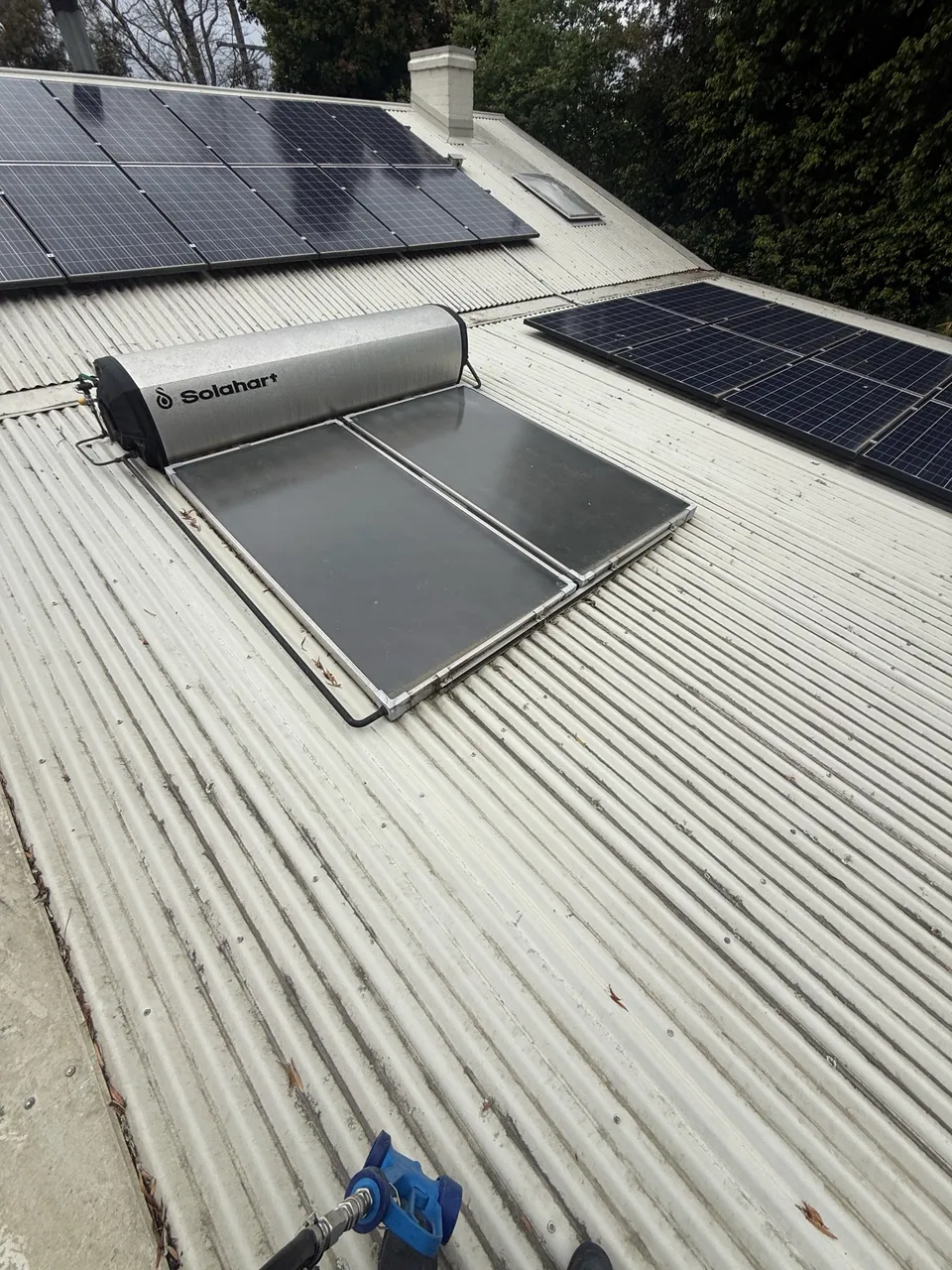 Clean metal roof with solar panels and a solar hot water unit after washing