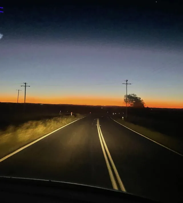 Empty country road at first light seen through the windscreen