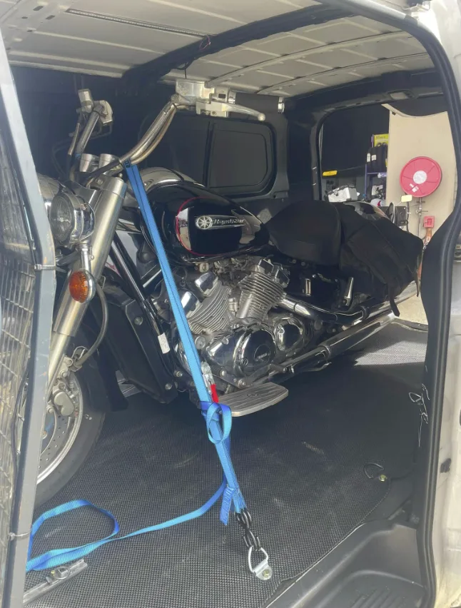 Yamaha cruiser strapped down inside the MotoMove van with blue ratchet straps