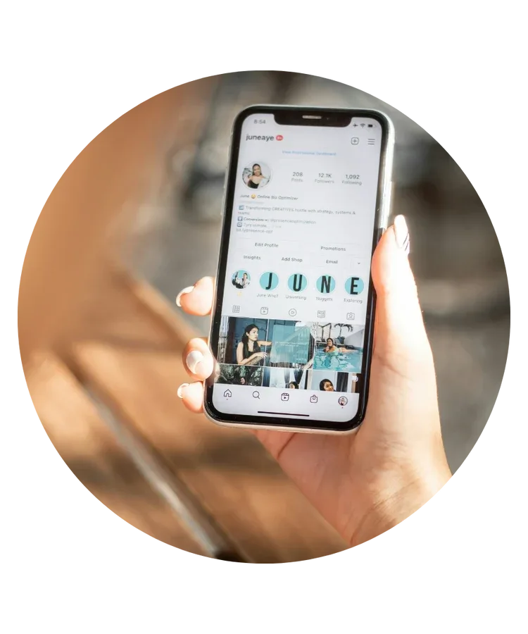 Hand holding a phone showing an Instagram feed